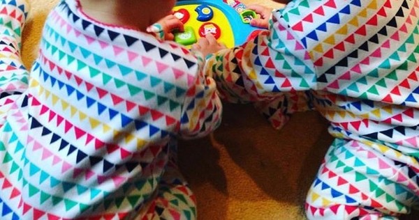Colourful bunting patterned babygrows and vests