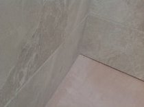Caulk or grout where the tiles meet the ceiling/walls?