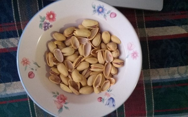 He opens a pistachio, discards half the shell in the same bowl, then sucks the nut out of the other half, then discards this half in the same bowl