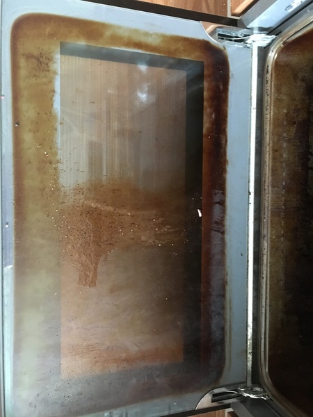 How can I clean my oven door glass?