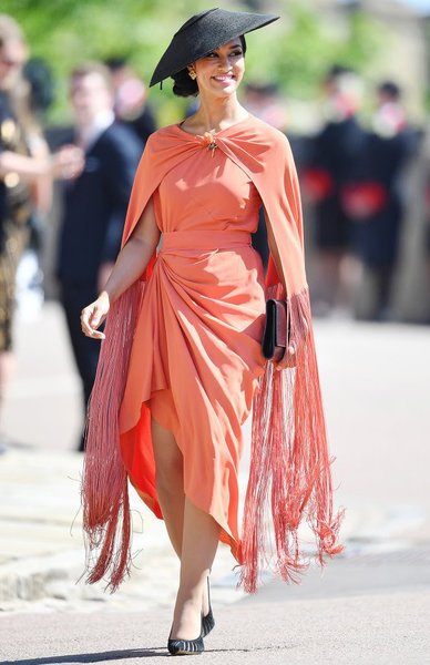 Who wore the orange dress and cape with a black hat yesterday?  She looked stunning but can find no mention of who she is anywhere.