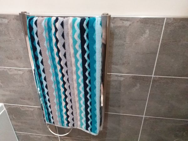 What colour towels in a grey tiled bathroom?
