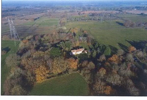 To look at a house near a big electricity pylon