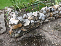 Does the patio surface/rockery wall exist today?