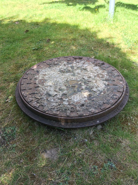 What to do with this humdinger of a manhole cover in my lawn?