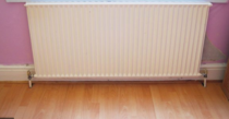 Laminate planks under radiators - which direction?