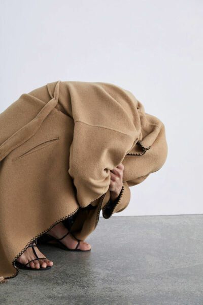 Standing pigeon-toed, looking at the ground while lightly touching your hair...