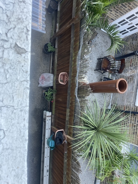 Is it legal to build a brick structure above the fence in a narrow patio?