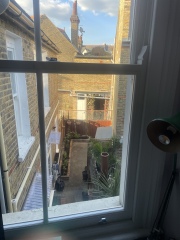 Is it legal to build a brick structure above the fence in a narrow patio?