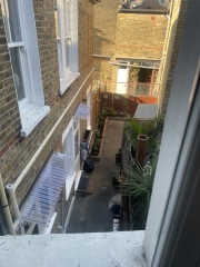 Is it legal to build a brick structure above the fence in a narrow patio?