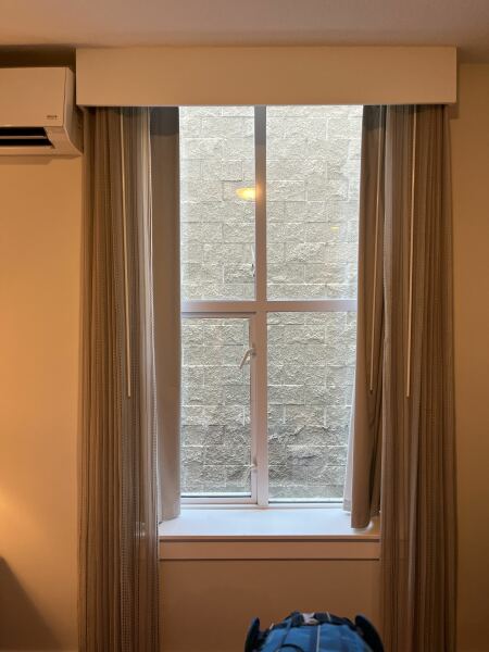 Hotel Room Windows Facing a Concrete Wall