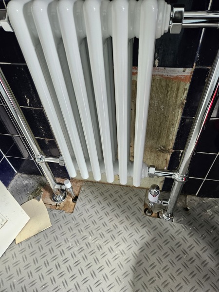 How to decorate untiled patch behind new bathroom radiator without removing it?