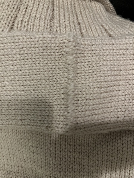 Fixing loose stitches on the back yoke of a knitted sweater