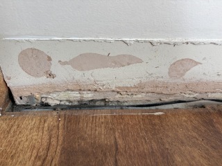 Who should I call about exposed brick behind loose skirting?