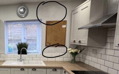 Could lumpy patches on rendered external walls indicate damp issues?