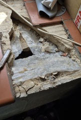 Why would an old utility room have a large concrete slab full of dirt?